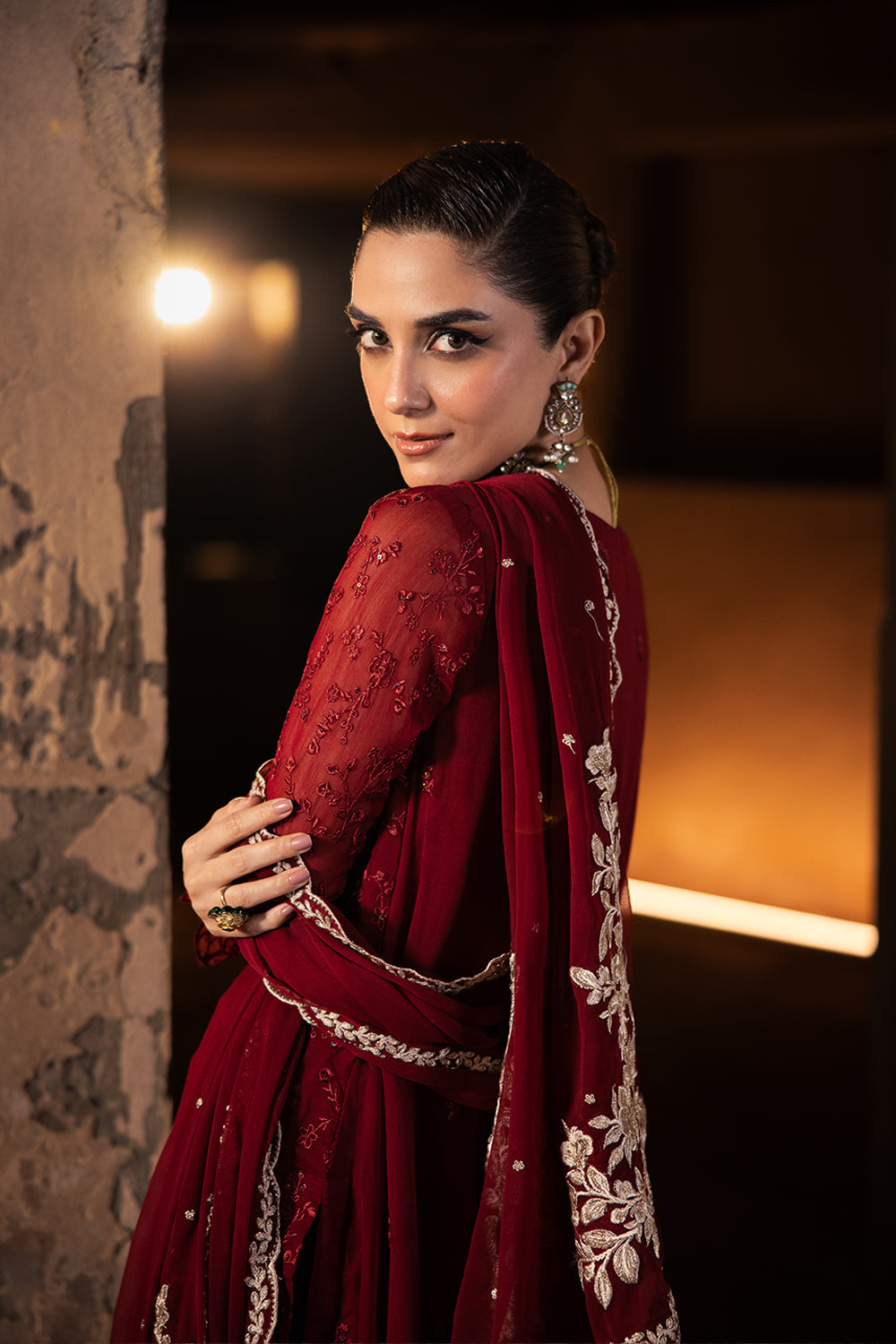 Woman in a red embroidered traditional outfit with a dark background